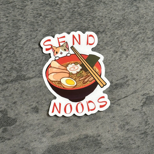transparent sticker with a kitty peering over the edge of a bowl of ramen. The text says send noods