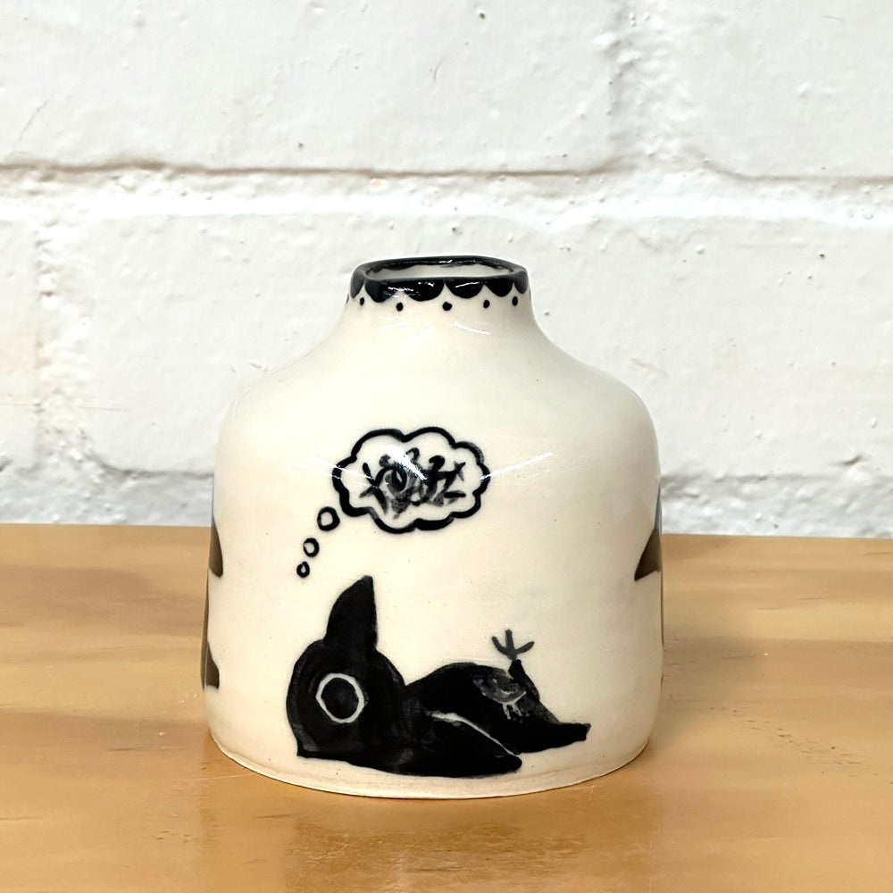 Wheel thrown vase in off white color with black crow design painted on. 